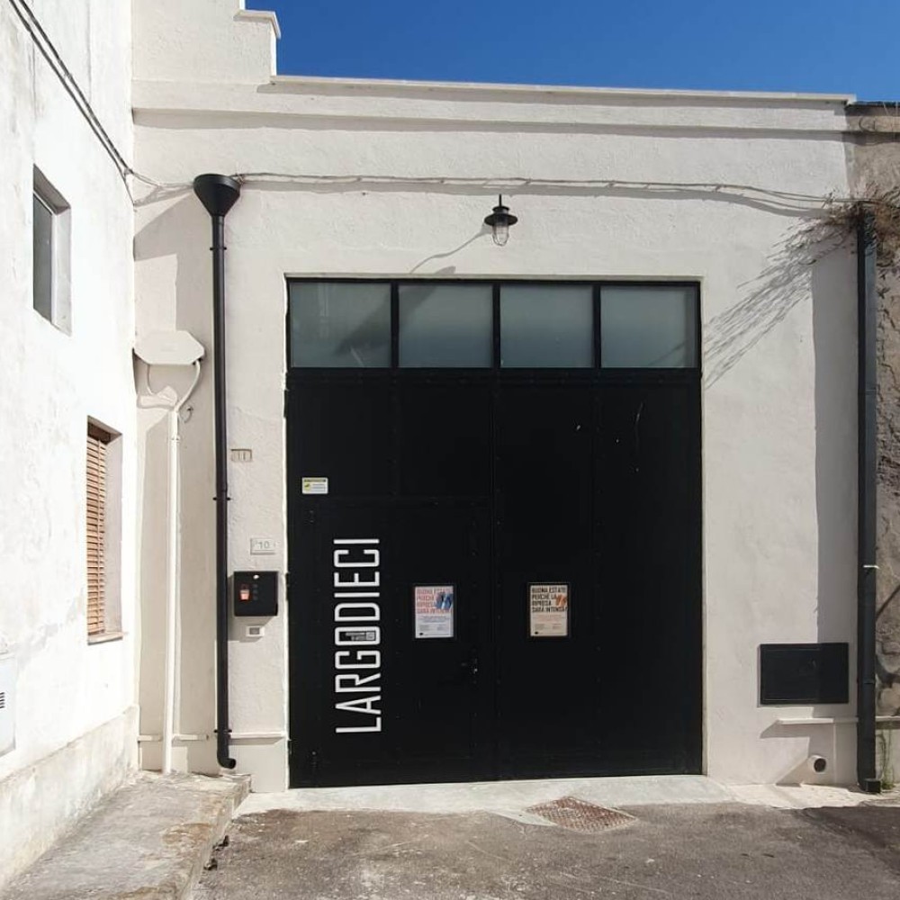 La façade du LARGO 10 et son portail noir marqué LARGODIECI, à Poggiardo